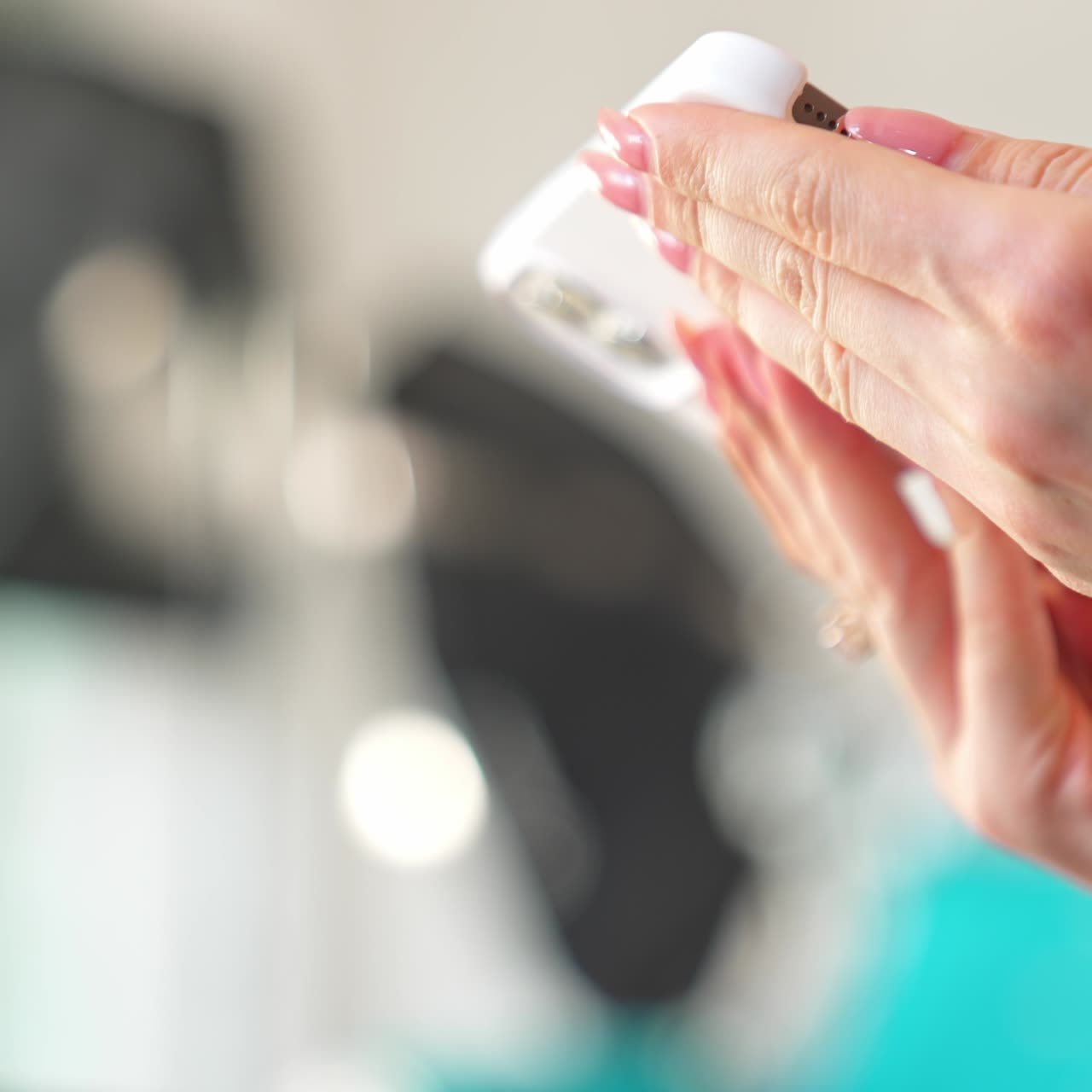 Browsing a new white up-to-date mobile phone. Female hands turn the mobile to see wider angle. Close up. Blurred backdrop