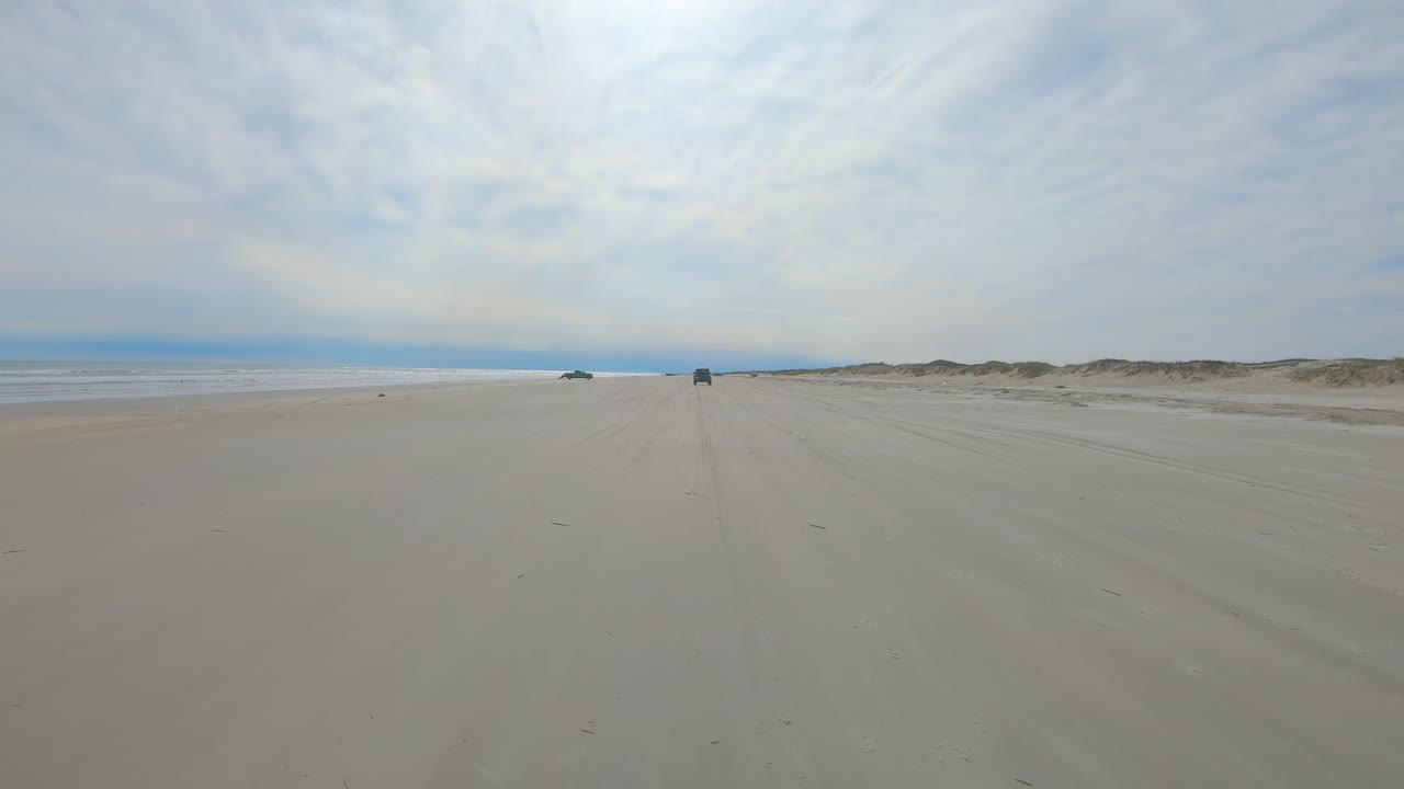 흐린 날 걸프 해안 방벽 섬에 있는 거의 황량한 해변에서 운전하는 동안 다른 차량과 어부가 거의 보이지 않습니다 - 노스 파드레 섬 텍사스