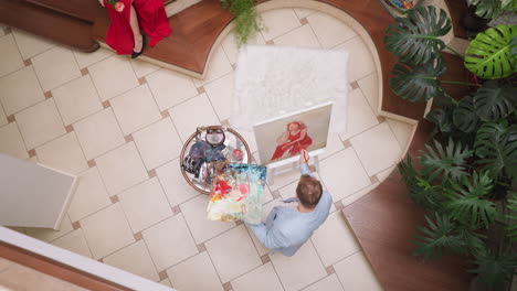 artist paints lady scarlet dress on canvas. man portraitist leaves brushstrokes on passionate woman picture in gallery. work with model in art shop