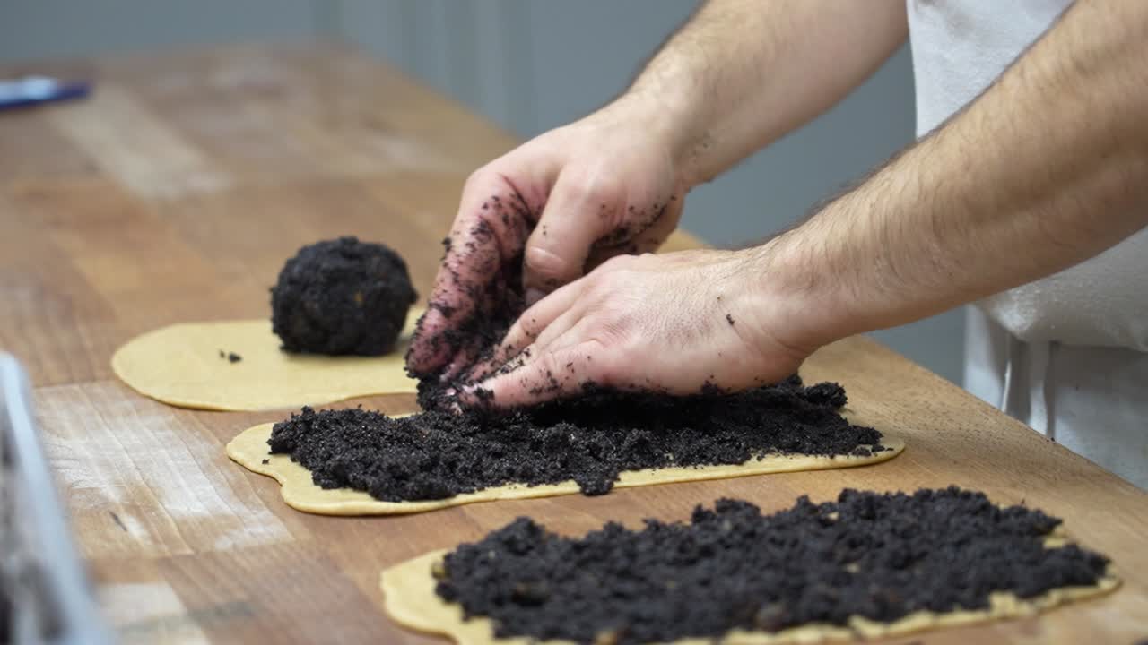 rellenar la masa de bejgli húngara con mezcla de semillas de amapola oscura para una pastelería tradicional de navidad