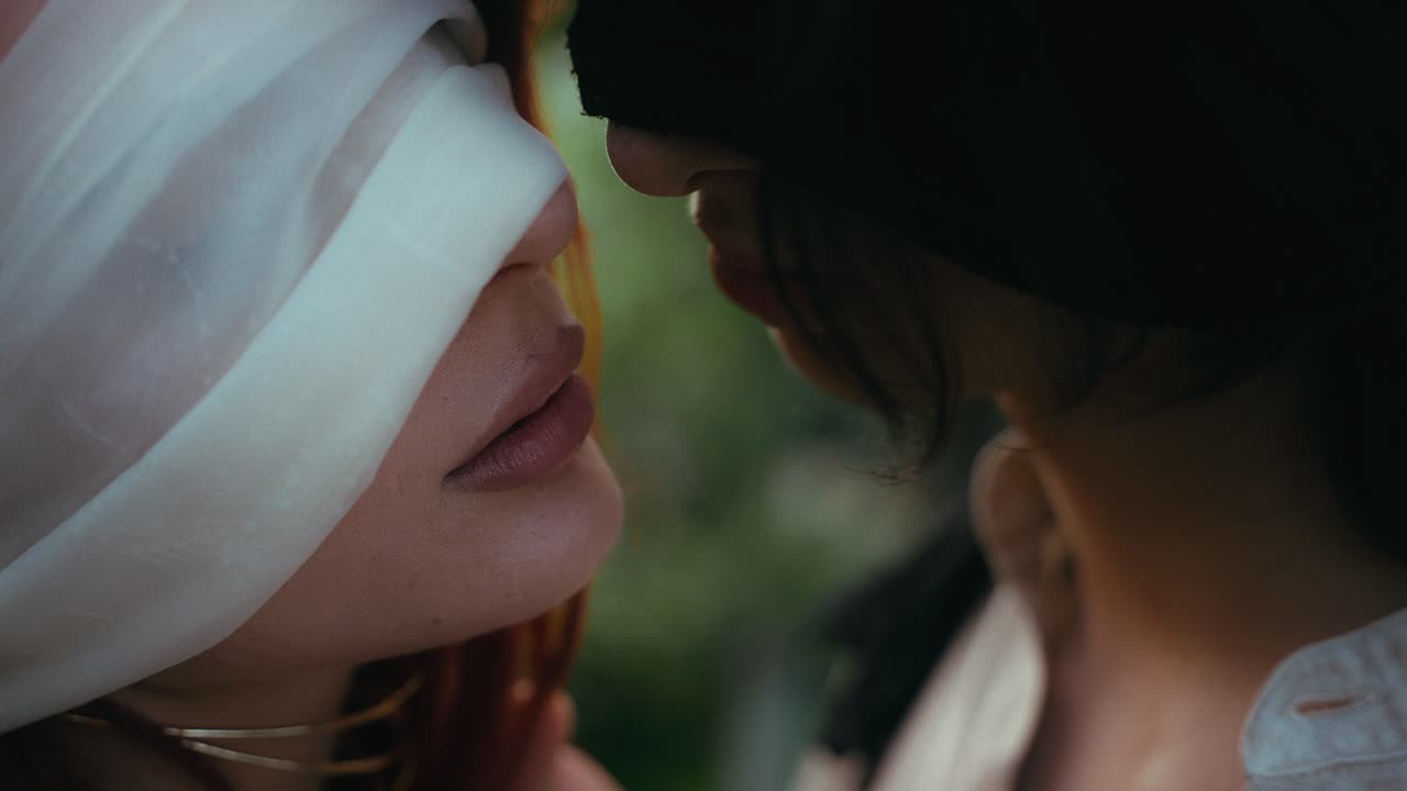 눈이 인 남녀가 키스하는 동안 부드럽게 만지는 영화적 클로즈업 비디오, 강렬한 감정적 연결을 포착합니다.