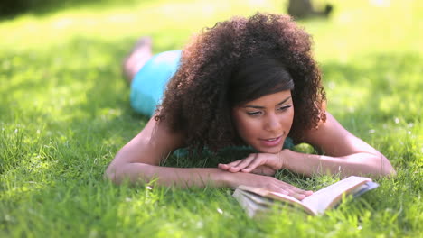una mujer hermosa leyendo en el parque.