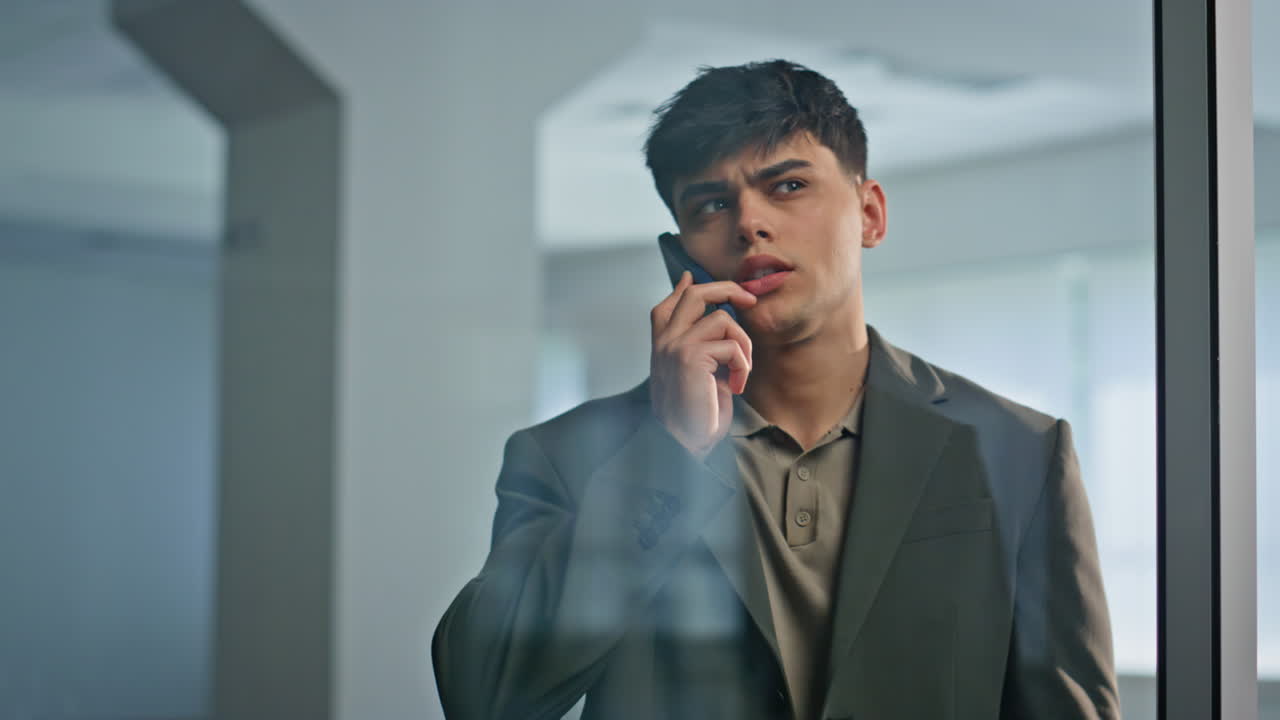 Worried business owner calling cellphone office hall closeup. Executive speaking