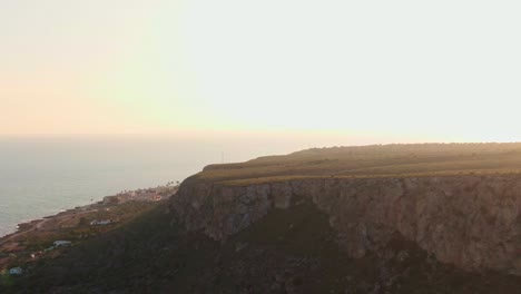 rocky beachside cliff near santa pola, spain during beautiful warm sunset.