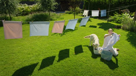 woman doing laundry outdoors with dog