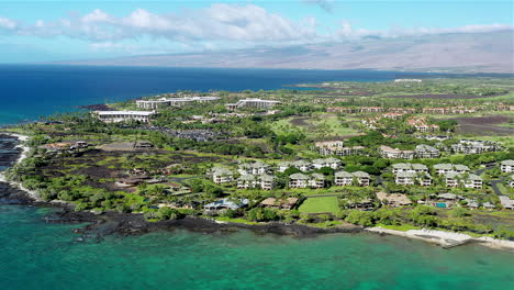 drone footage of the ocean, condos, and housing along the coast of the big island of hawaii