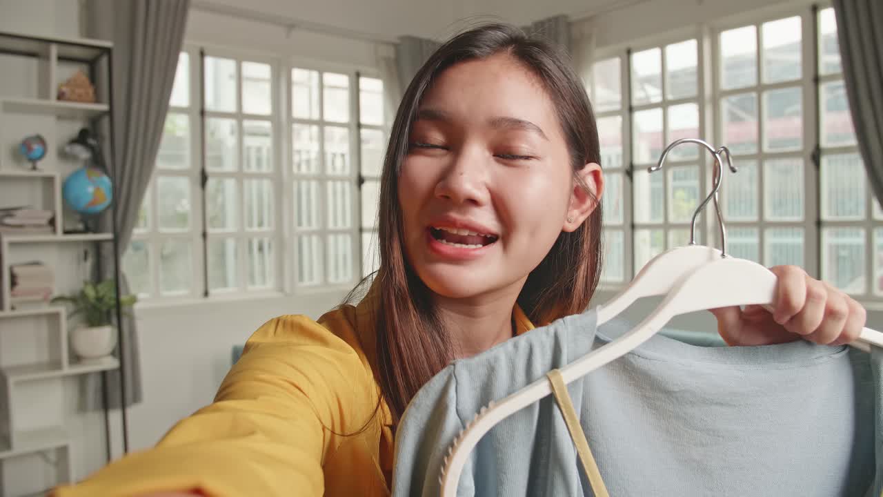 Young Girl Fashion Blogger Or Woman Holding Camera And Showing Casual Colorful Shirts For Sell Online, Selfie