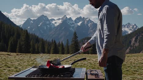 man grilling steak in the mountains