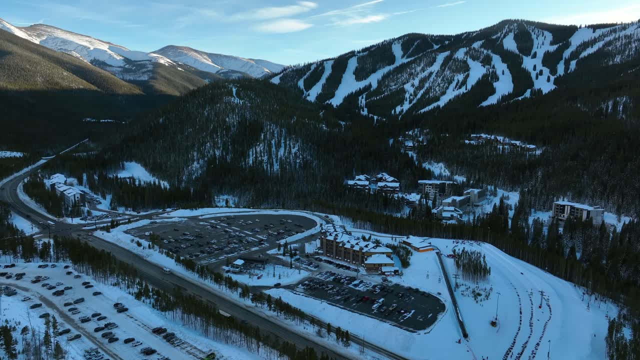 estación de esquí de colorado del parque de invierno en las montañas rocosas en un día claro de invierno. coches en el estacionamiento frente al área de la base. sobrevuelo aéreo de drones