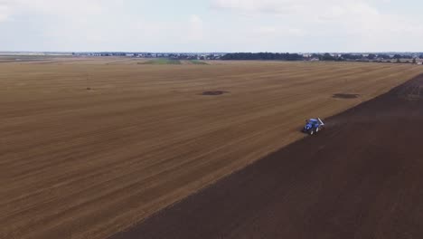 blue modern plowing tractor working in the field-7