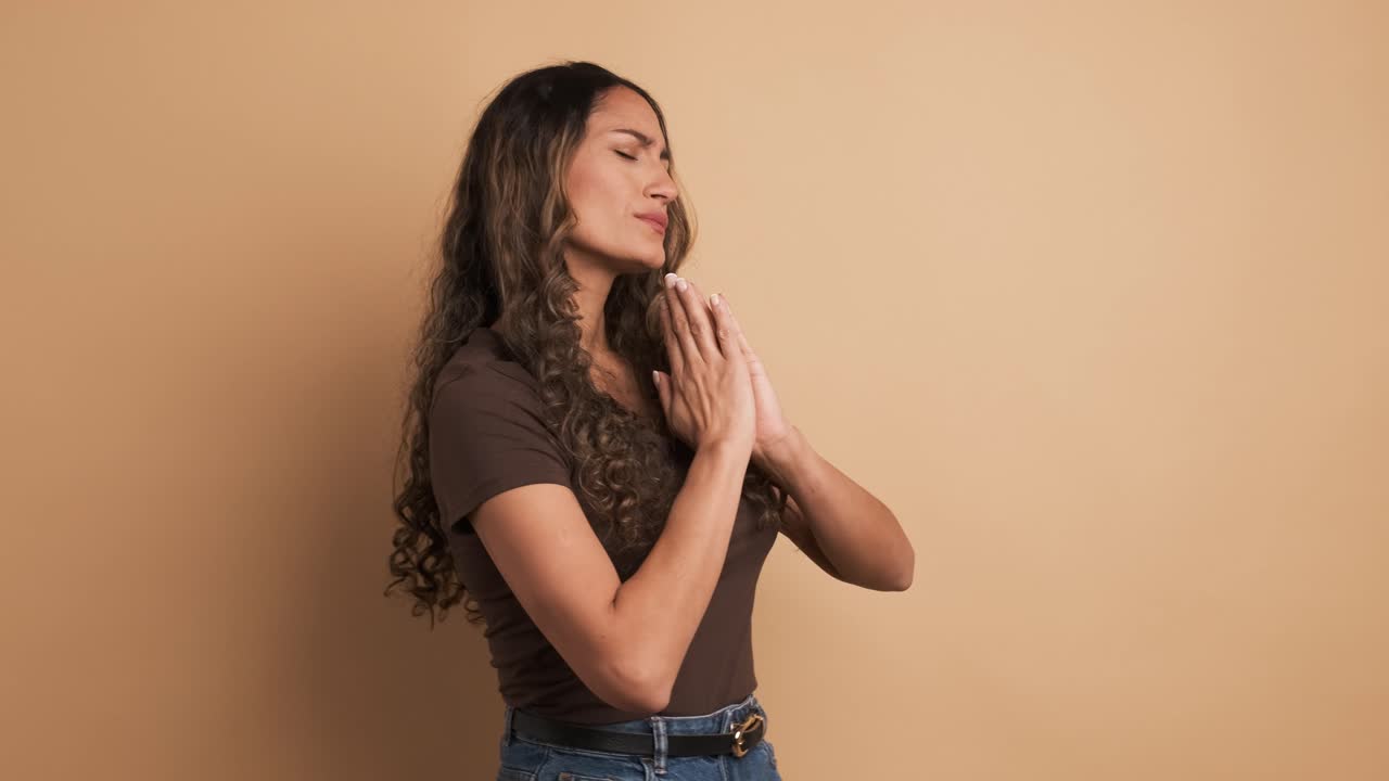 An hispanic woman closing eyes and praying