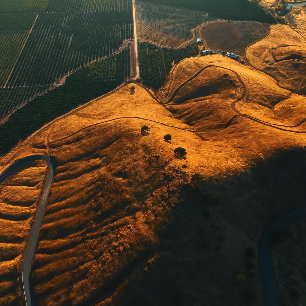 Splendid view of the rolled bare rocks neighboring with green vineyards in California. Highway passes by the surface of mountain. Top view