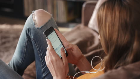 mujer hermosa feliz escuchando música auriculares escribiendo mensajes usando teléfono inteligente en el sofá en casa estilo de vida relajante