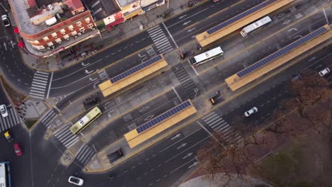 aerial top down of public bus station in chacarita district of buenos aires - cars driving on road on junction