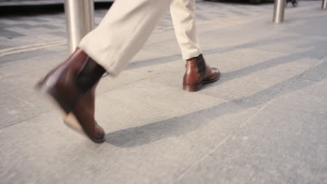 close crop of businessman feet walking in city