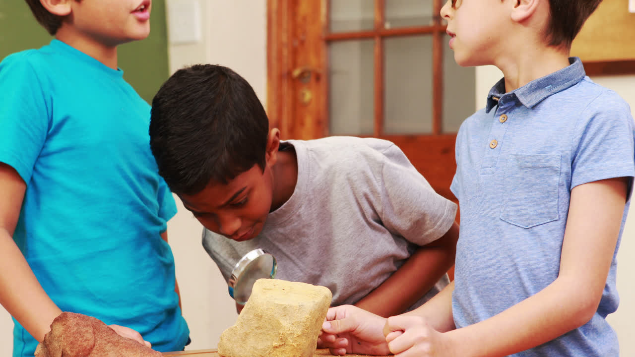 alumnos mirando la roca con lupa