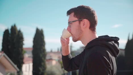 young man drinking coffee espresso in sun on balcony