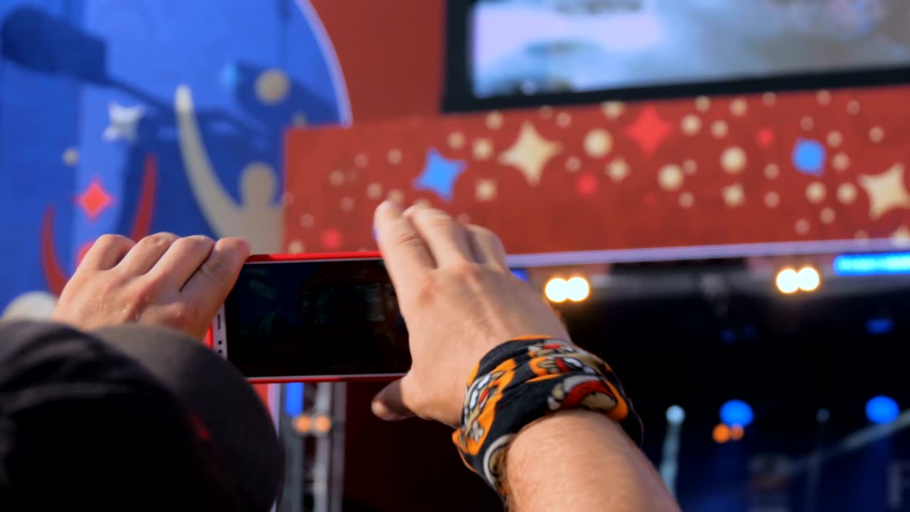 스마트폰으로 라이브 음악 콘서트의 비디오를 녹음하는 손 실루