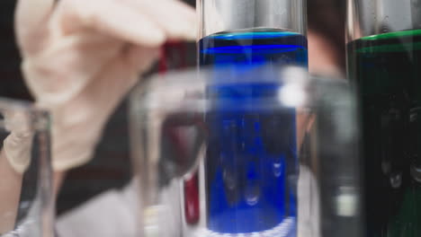 row of test tubes with liquids and doctor checking sample