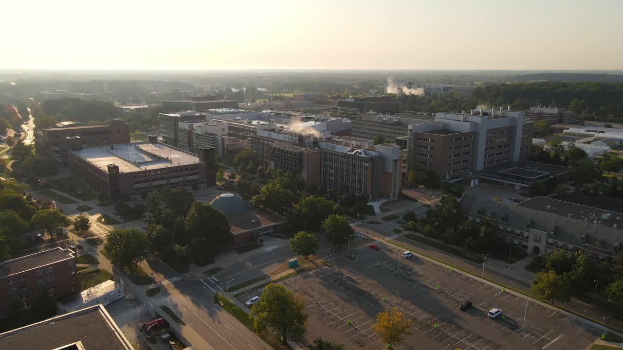 Buildings of Michigan State university with steaming chimneys, aerial drone view