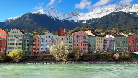 Innsbruck-Austria-colorful-pastel-buildings-capital-Tyrol-Tyrolean-Alps-mountain-backdrop-the-bridge-over-the-Inn-River-Innbrücke-clear-blue-sky-clouds-October-November-autumn-fall-sunny-static-shot