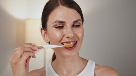 mujer cepillándose los dientes con aparatos dentales