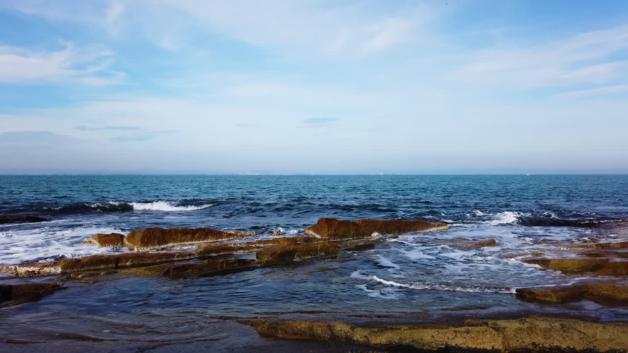 Motion time lapse of picturesque rocks on Black sea shore. Waves, sea foam, small boat. Hyperlapse on summer day in Chernomorets, Bulgaria.