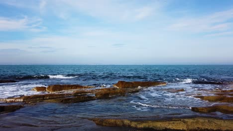 motion time lapse of picturesque rocks on black sea shore. waves, sea foam, small boat. hyperlapse on summer day in chernomorets, bulgaria.