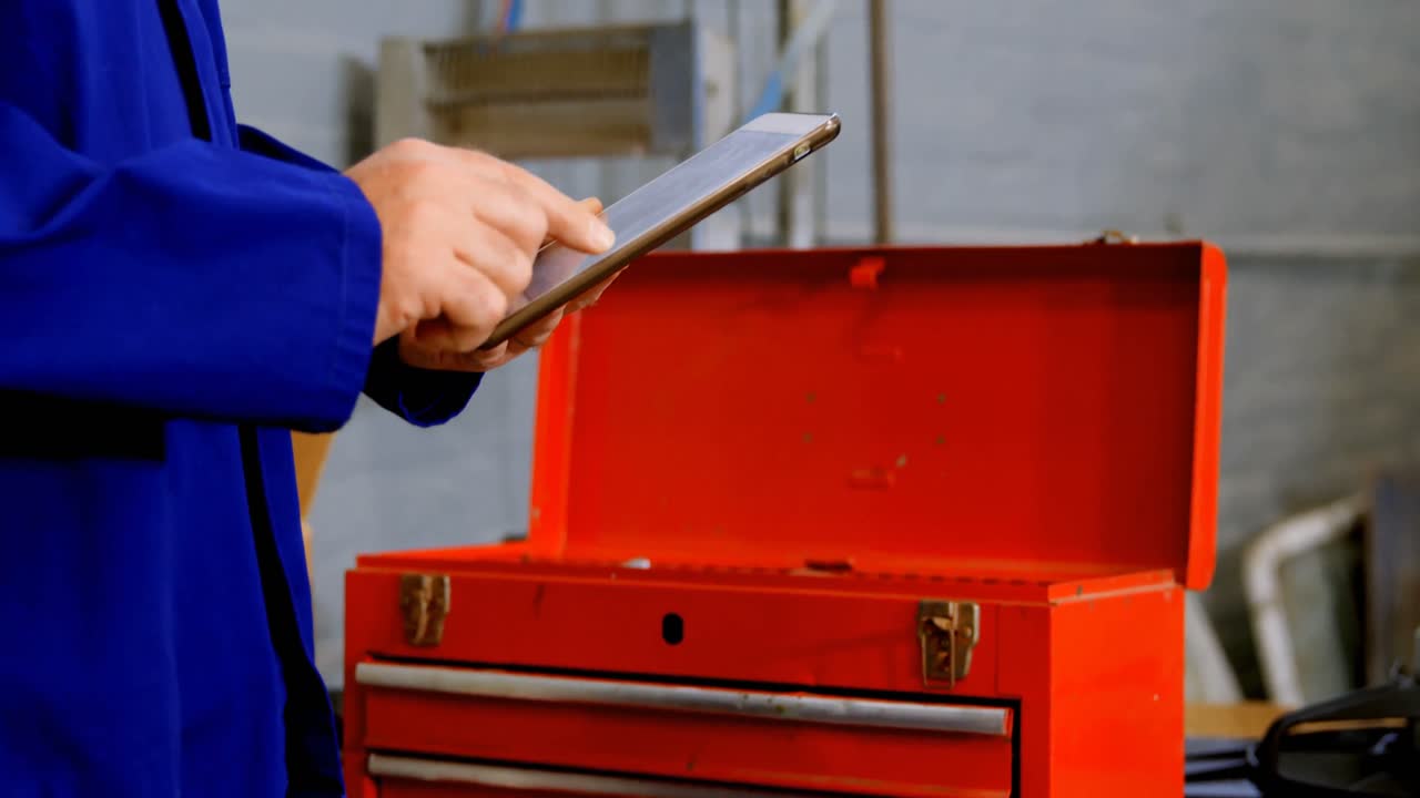 Mechanic using digital tablet in garage 4k