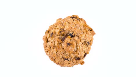 top view from above of one oatmeal raisin cookie rotating on the turntable. isolated on the white color background. macro.