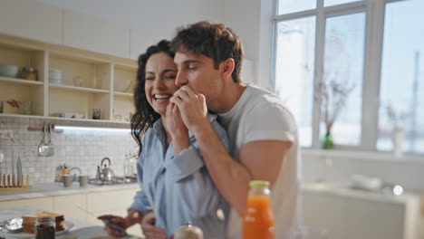 lovers having fun cooking romantic breakfast together at modern kitchen close up