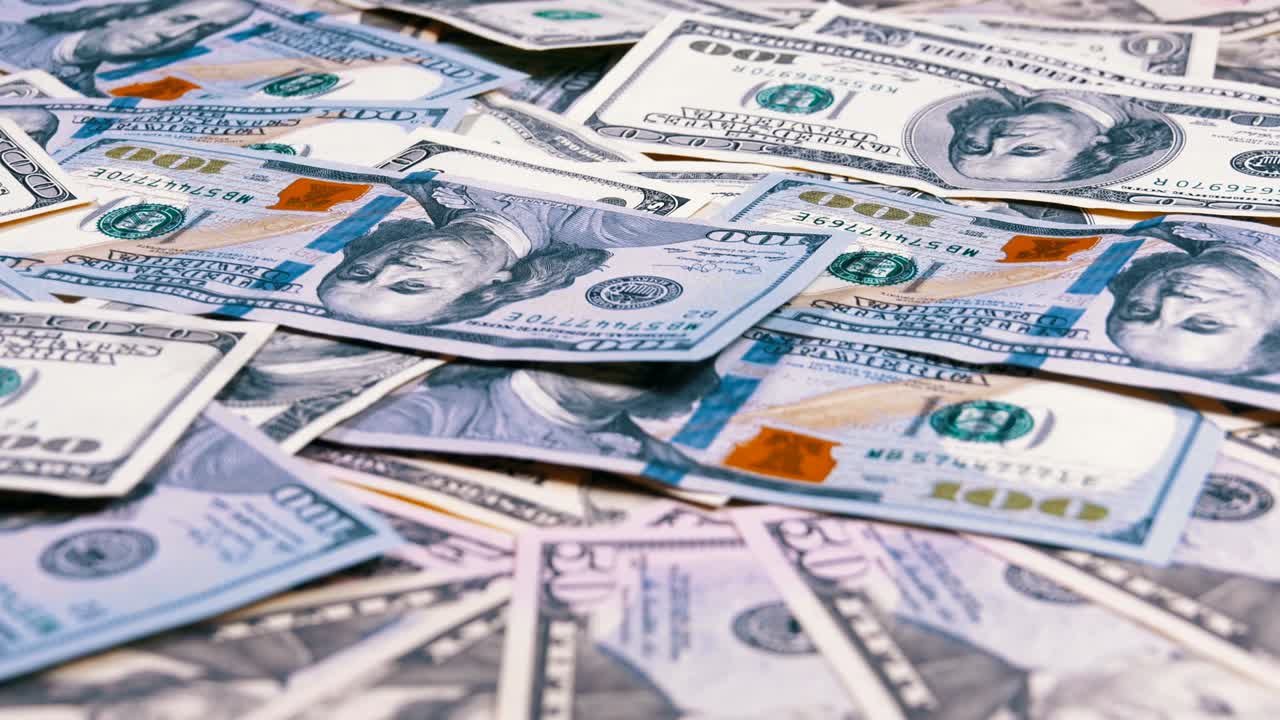 billetes de dólares estadounidenses de diferentes denominaciones girando en la mesa