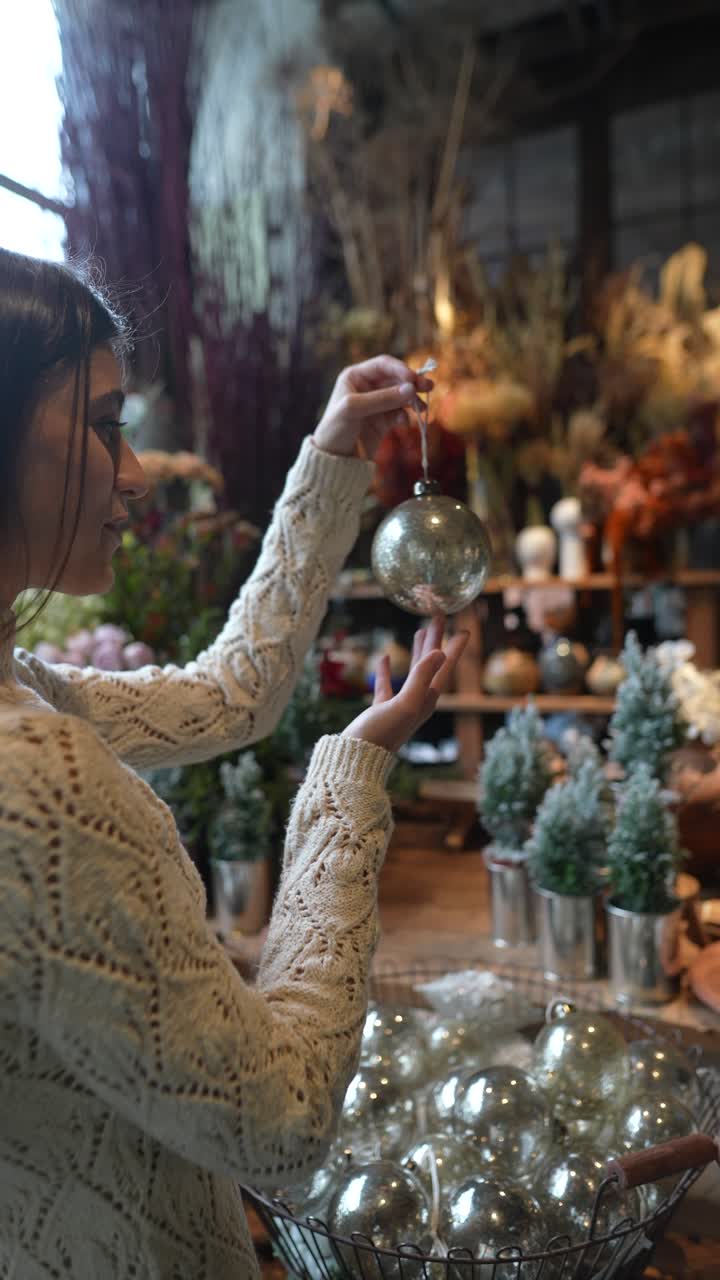 mujer comprando adornos de navidad en una tienda de flores