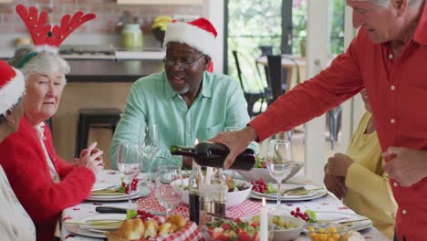 Happy-group-of-diverse-senior-friends-celebrating-meal-at-christmas-time