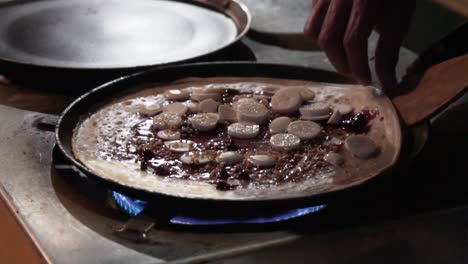 plegando un crepe en una sartén en cámara lenta en un mercado callejero
