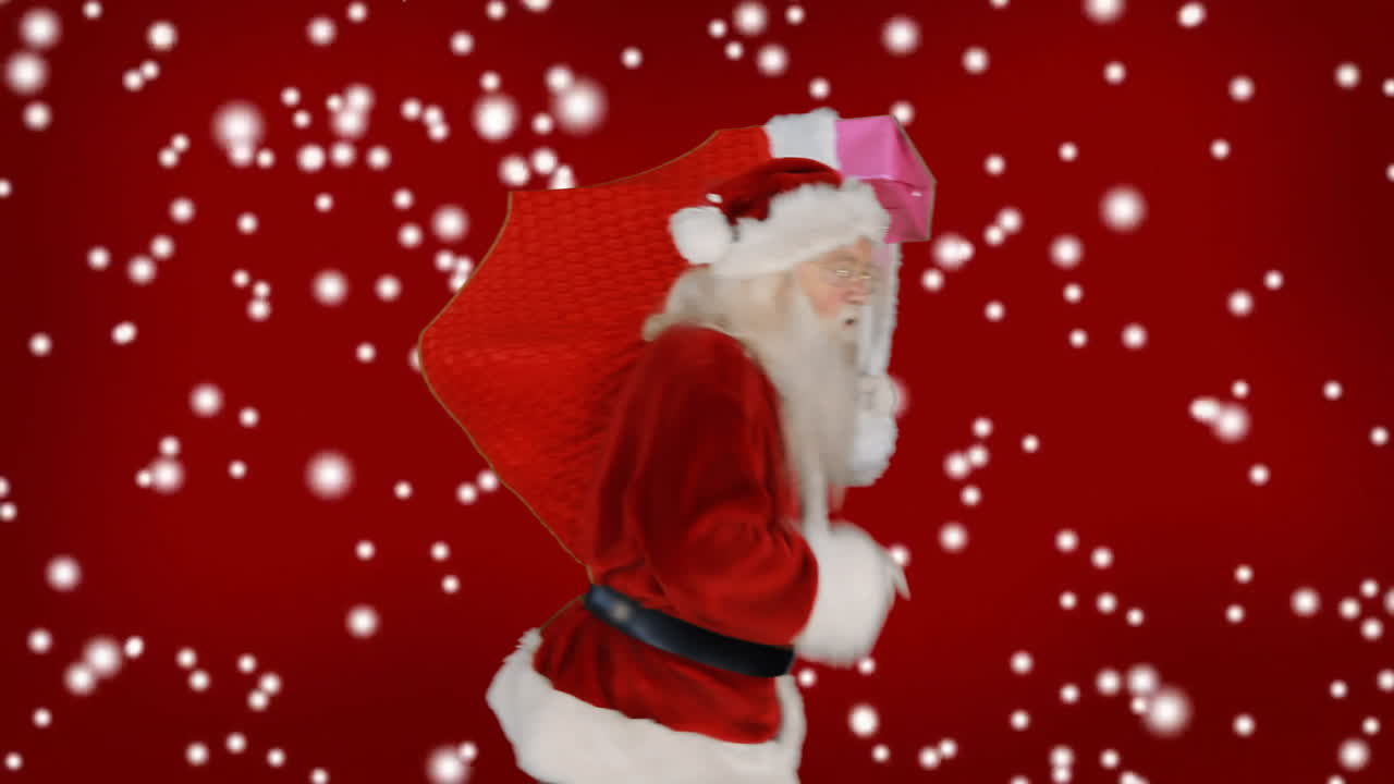 Santa Claus carrying gift bag over falling snow animation on red background