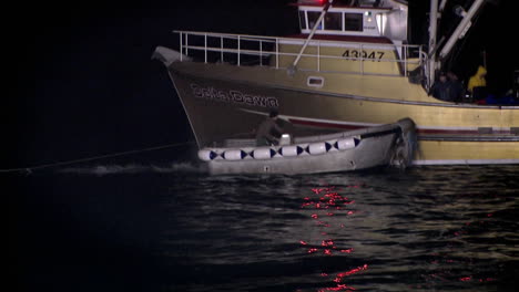 A-man-moves-around-on-the-deck-of-a-boat-sitting-in-the-water