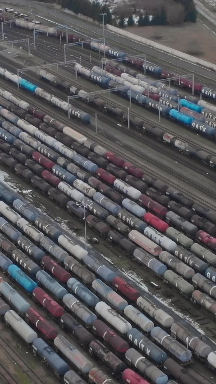 Eisenbahnwaggons stehen am späten Nachmittag auf einem Rangierbahnhof in der Nähe einer Stadt.