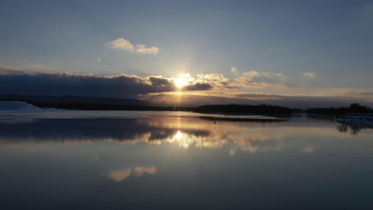 puesta de sol de invierno sobre un río congelado