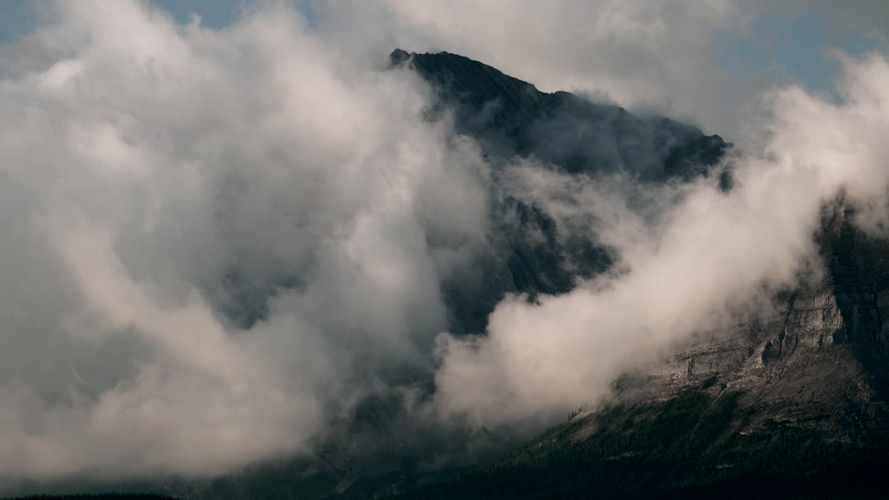Thick White Clouds Moving With The Wind Through The Mountains - Timelapse