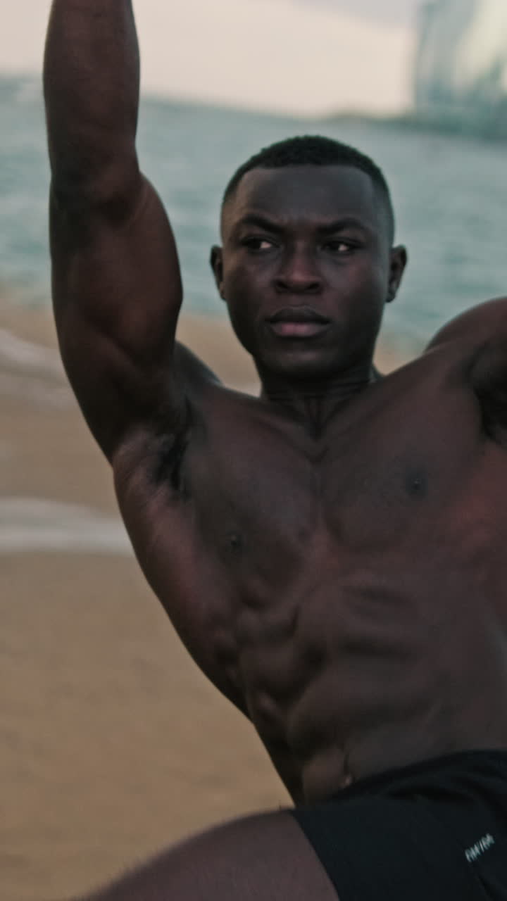 Muscular Young Man Exercising on a Sandy Beach