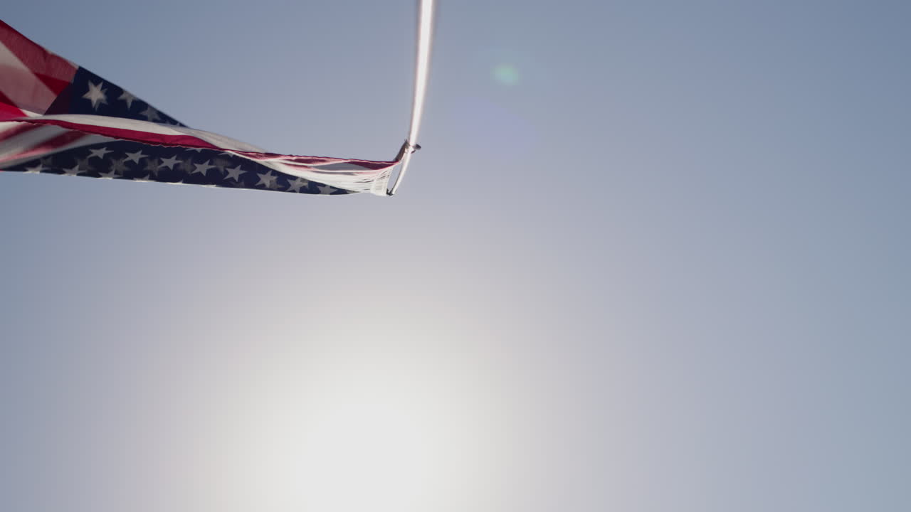 ondeando la bandera americana en un poste contra el cielo azul