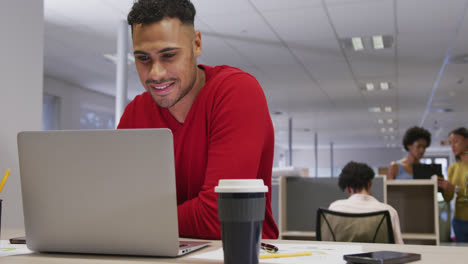 Glücklicher-Biracial-Geschäftsmann-Mit-Laptop-über-Geschäftskollegen-Im-Büro