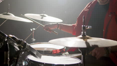 young male drummer playing drums at music studio