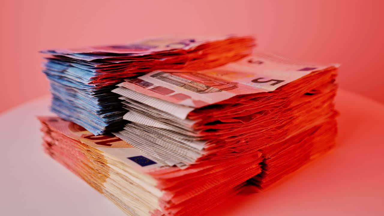 Euro banknotes spin in slow motion under red light, symbolizing financial risk