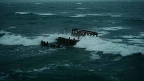 a shipwreck slowly succumbs to the relentless waves of a stormy sea, showcasing nature's power and the inevitable passage of time over forgotten vessels