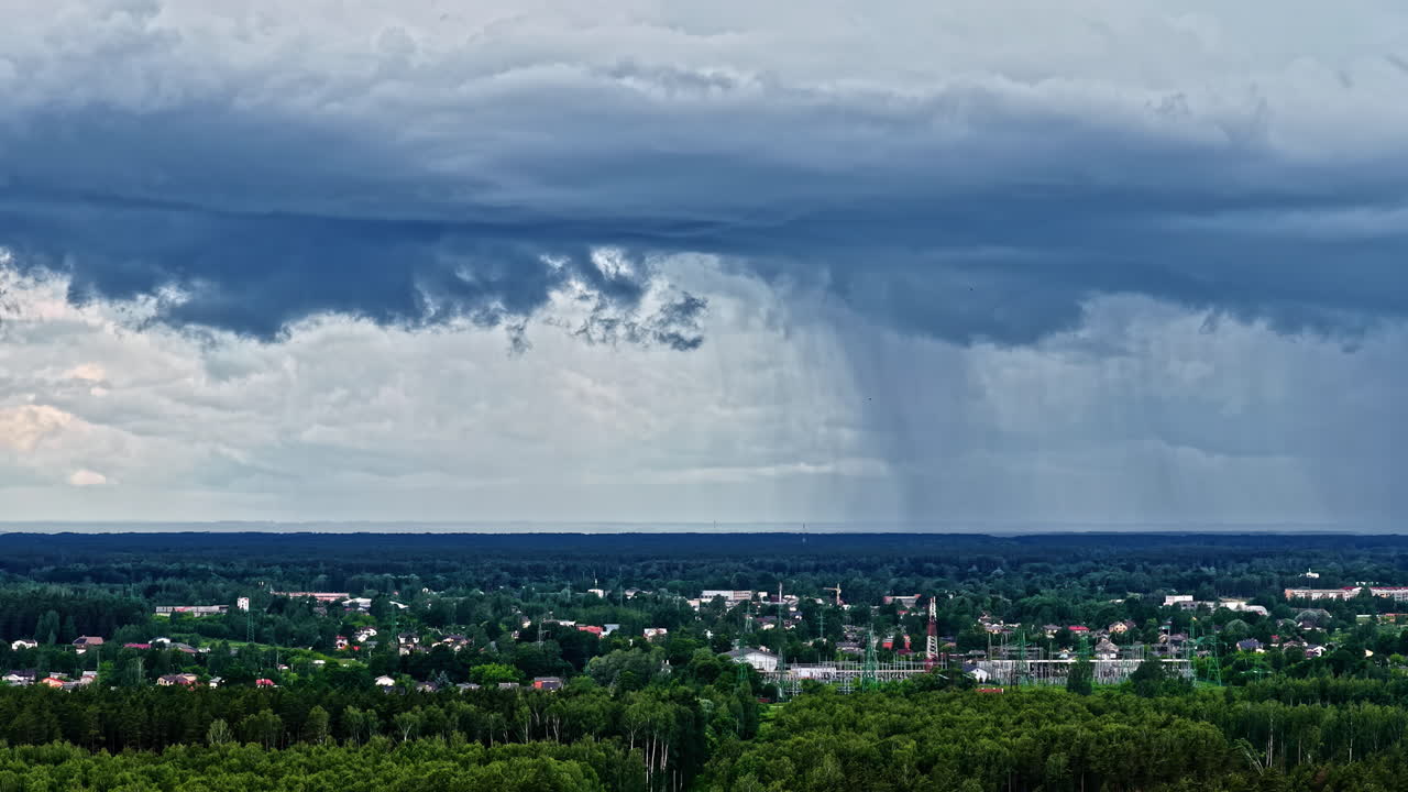 Storm clouds pouring rain on cityscape, aerial time lapse view