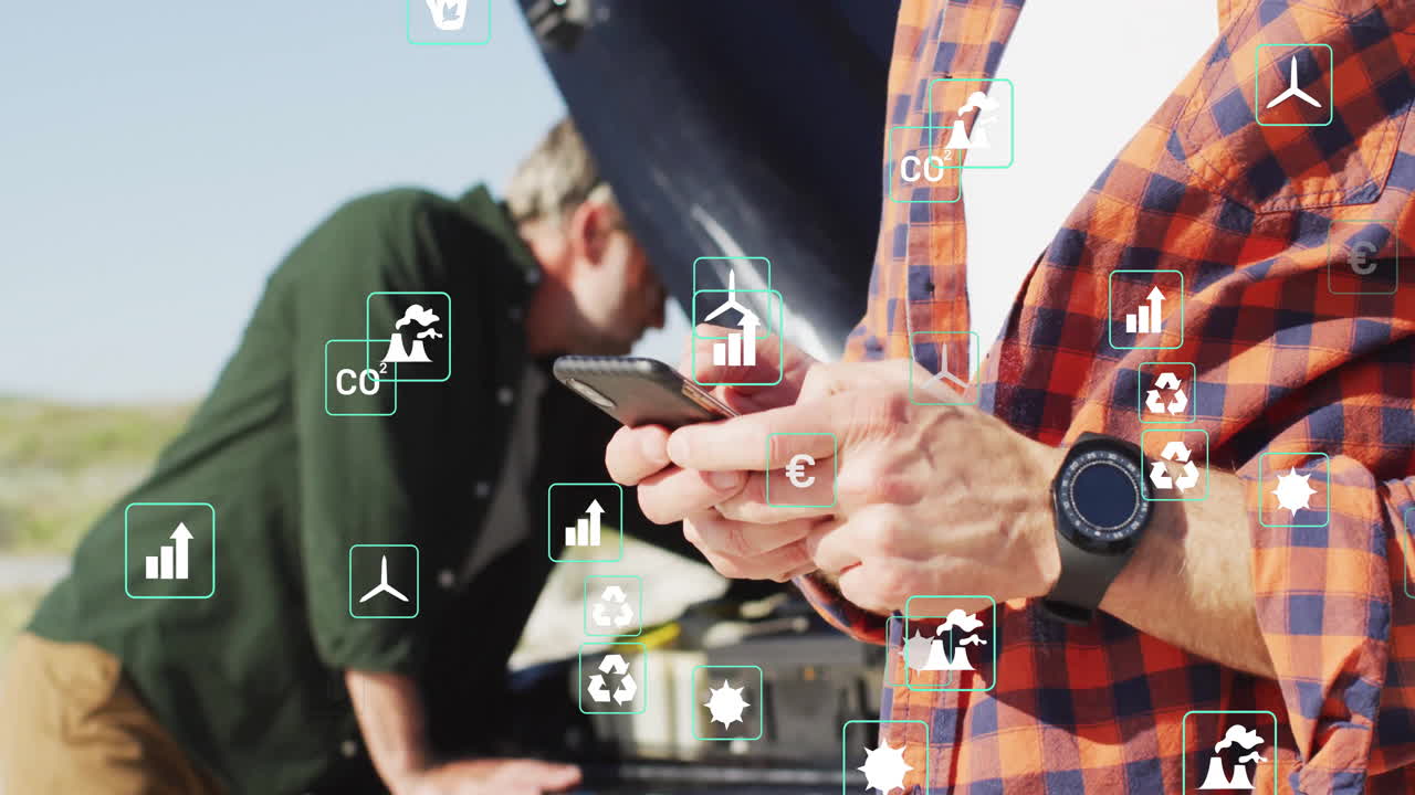 Mechanic tapping smartphone outdoors, colleague inspecting engine, overlaying sustainability icons
