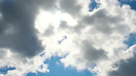 cielo azul con nubes esponjosas y sol