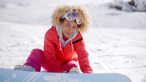 skier attaching a snowboard to her boots